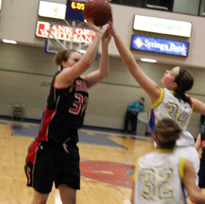 Kara Guyer shoots through a shot block attempt against Genesee.