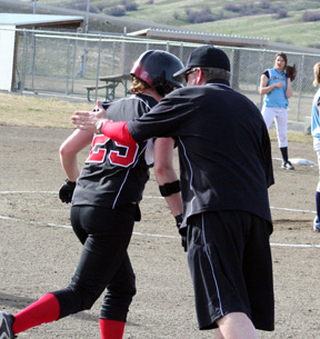 Coach Jeff Martin congratulates Kara Guyer as she rounds third after her 3-run homer against Grangeville.