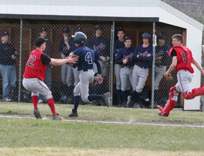 Pitcher Eric Daly tags out a Lewis County runner as catcher Kyle Holthaus backs up the play.