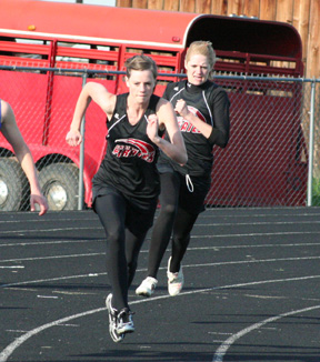 Katie Nuxoll is about to hand off to MaKayla Schaeffer in the 4x100 relay.