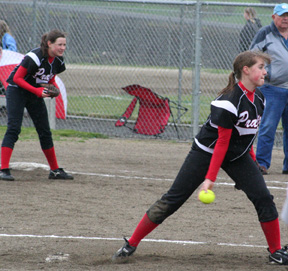 Megan Sigler pitches against C.V. in Prairie's district tournament opener. In the background a cold, wet Meghan Bruner gets ready for a possible play.