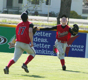 Leftfielder Silas Whitley and shortstop Kyle Holthaus both are running full tilt after a fly ball. After they collided Whitley had to leave the game with an injured hand.