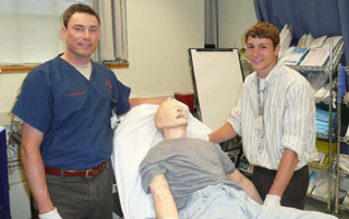 Conner Rieman, Prairie High School senior, is pictured with David Lindquist, MD, an ER physician. Rieman learned some diagnostic techniques using a simulation mannequin during a ten day National Youth Leadership Forum/Medicine in Boston.