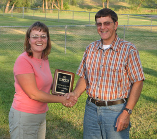Joe Cladouhos, CEO, presents the Employee of the Year Award to Teresa Lustig, Grangeville Clinic receptionist.