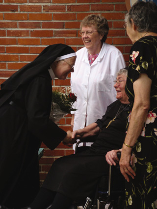 Abbess Pia Habermacher greets Sister Petronilla Lieser. Also pictured, Sister Mary Geis (center) and Sister Mary Bernard Lieser.