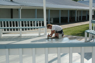 Laurie Lorentz puts a fresh coat of paint on the gazebo to prepare it for the fair.