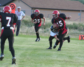 Garrett Schmidt carries the ball inside the 10 yard line. Also shown are Beau Schlader, 7, and Cody Schumacher, 35.