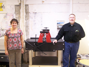PHS art teacher Sonesa Lundmark and George Hager with the hand-powered printing press he built and donated.