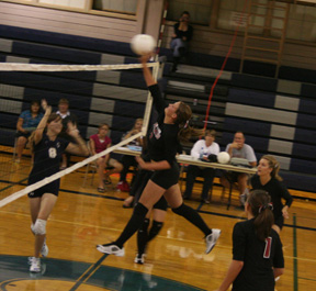 Casey Bruegeman hits the ball as Bruner and Duman watch. Setter Megan Sigler is hidden behind Bruegeman.