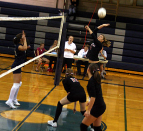 Shelby Duman spikes the ball against Grangeville as Kayla Johnson and Meaghan Bruner watch.
