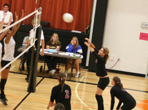 Shelby Duman gets the ball over the net against Asotin at the Kendrick Tournament. Front from left are Casey Bruegeman and Megan Sigler.