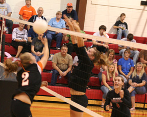 Casey Bruegeman blocks the ball for a point in Prairies match against Troy last Thursday. Megan Sigler watches.