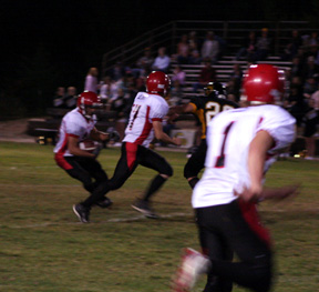 Tyrell Langston cuts back to the right after taking a handoff from Kyle Holthaus, center. He wound up going  33 yards for a touchdown on the play. At right is David Sigler.