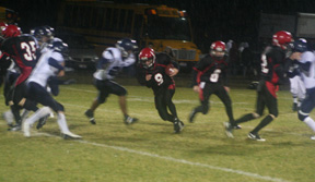 Brock Heath goes through a huge hold made in large part by clocks by Cody Schumacher, 35, left, and  Derek Schaeffer, right. Behind Heath is Troy Lorentz, 8.