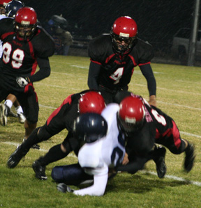 The Prairie defense tackles the Lapwai ballcarrier for a loss. Derek Schaeffer is on the right and were not sure who the other tackler is. Devin Schmidt, 4, and Kyler Shumway, 99, move in.