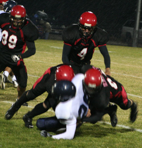 The Prairie defense tackles the Lapwai ballcarrier for a loss. Derek Schaeffer is on the right and we’re not sure who the other tackler is. Devin Schmidt, 4, and Kyler Shumway, 99, move in.