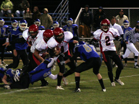Devin Schmidt is shown powering through the middle on a running play. Behind him are Joe Schumacher and Branden Waller. At right is Conner Rieman.