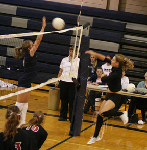 Shelby Duman spikes the ball against Grangeville. At left are Sam Frei and Kayla Johnson.