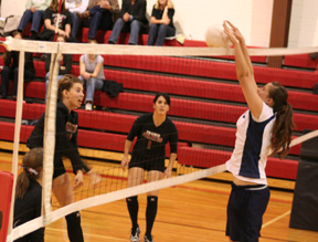 Summit's Tara Stubbers stuffs the spike of Prairie's Sam Poxleitner as Francesca Johnson watches.