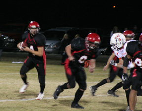 Devin Schmidt heads for a touchdown as Branden Waller, 6, prepares to block a Troy defender. At right is Kyler Shumway.