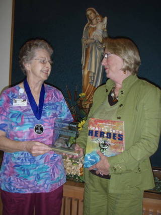 Marilyn Becker, RN, receives the Award as a Health Care Hero in the Nursing Category from Iris Hawley who accepted the plaque at a Boise ceremony hosted by the Idaho Business Review, IHA, IMA, ISU and other health entities.