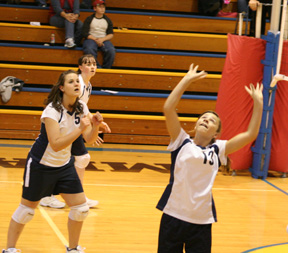 Brooke Schumacher gets ready to set the ball. Also shown are Tara Stubbers and Nicole Frei.