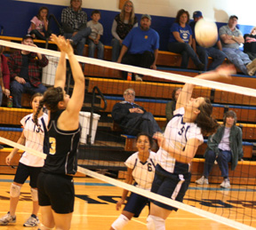 Tara Stubbers prepares to spike the ball against Highland as Brooek Schumacher, 13, and Margaret Yalbuw look on.