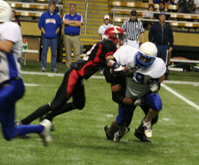 Derek Schaeffer and Branden Waller tackle Raft River's H.D. Tuckett for a loss.