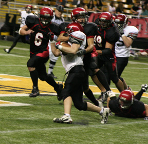 Tyrell Langston tackles Wallaces Nathan Cook for little or no gain as Branden Waller, 6, and Kyler Shumway, 99, move in.