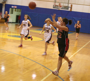 Haleigh Schmidt makes a pass on a fast break. In the background are Meaghan Bruner and Megan Sigler.