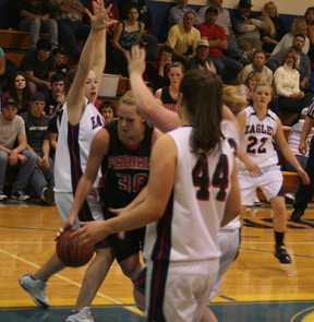Mary Shears splits a double team as she tries to get to the hoop. At right is NaTosha Schaeffer.