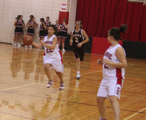 Amber Holthaus runs a break after a Kamiah turnover. At right is Haleigh Schmidt.