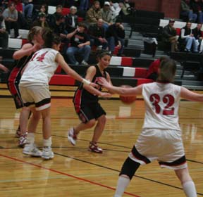 Amber Holthaus dribbles into the lane against Deary. At left is Mary Shears.