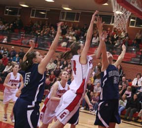 Prairie's MaKayla Schaeffer shoots as Summit's Savanah Prigge tries to block the shot. Others from left are Prairie's NaTosha Schaeffer, Summit's Tara Stubbers and Prairie's Kayla Johnson.