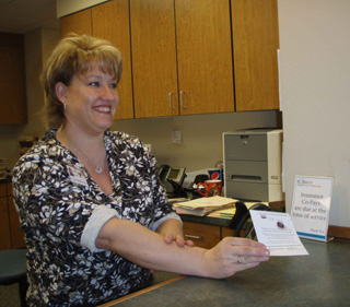 Stacie Jackson, SMHC Clinic Admissions, shows a patient a satisfaction survey reminder card. Surveys will be mailed to many of the patients using the SMH clinics in Cottonwood, Nezperce, Craigmont and Kamiah. Patients are encouraged to return their survey in the self addressed stamped envelope.