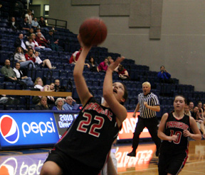 Amber Holthaus goes for a lay-up against Troy. At right is Megan Sigler.