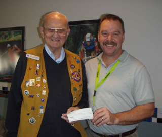 Carl Schmidt, Cottonwood Lions Club Treasurer, hands a check to Don Murphy, SMHC Physical Therapist, to help with the purchase of a DXA scan.