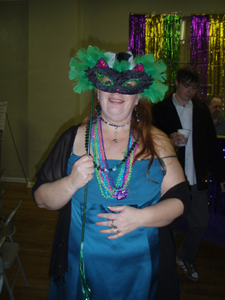 A Mardi Gras party goer gets into the spirit of things. Her mask can be used again at next years event.