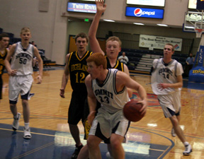 David Johnson gets ready to go up for a lay-up against Highland at the District Tournament. At left is Josh Schlader and at right is Dylan Prigge.