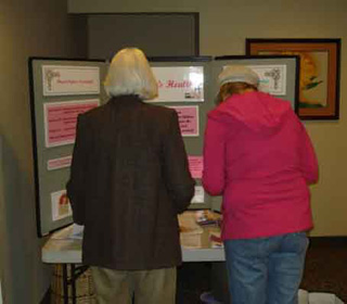 Two attendees take educational materials from the womens health display at the first SMHC Ladies Night Out. The next is scheduled for April 15th.