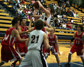Branden Waller is surrounded by defenders as he puts up a shot. Also shown is Conner Rieman.