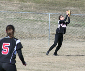 Alena Hoene makes a catch in right field as Megan Sigler looks on.
