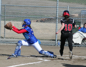 Amber Holthaus scores as she beats the throw to the plate.