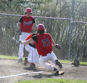 David Sigler slides in safe at home in the Troy game after a little league home run where he doubled, went to third on a throw home and scored when the throw got away from the catcher. Watching the action is Kyle Holthaus.