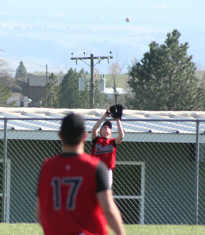 Silas Whitley is about to catch a fly ball in right field against Troy. #17 is Kyle Holthaus.