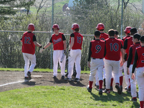 Devin Schmidt is greeted at the plate after his leadoff homer against Kendrick.