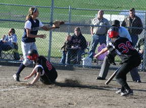 Haleigh Schmidt scores on a passed ball against Genesee as Alena Hoene, right, tells her to slide.
