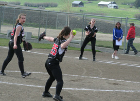 Monica Lustig gets ready to throw out a Lapwai runner from third base. Kendal Schumacher awaits the throw at first while pitcher Megan Sigler watches.