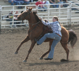 Kelsey Tidwell dismounts in the goat-tying event at the high school rodeo in Weiser.