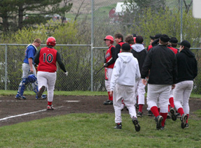 Joe Schumacher is greeted by the rest of the team at home plate after his home run against Orofino.